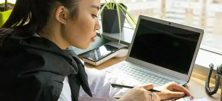 A  woman next to a laptop
