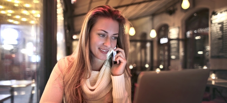 A woman happily talking on the phone in a restaurant