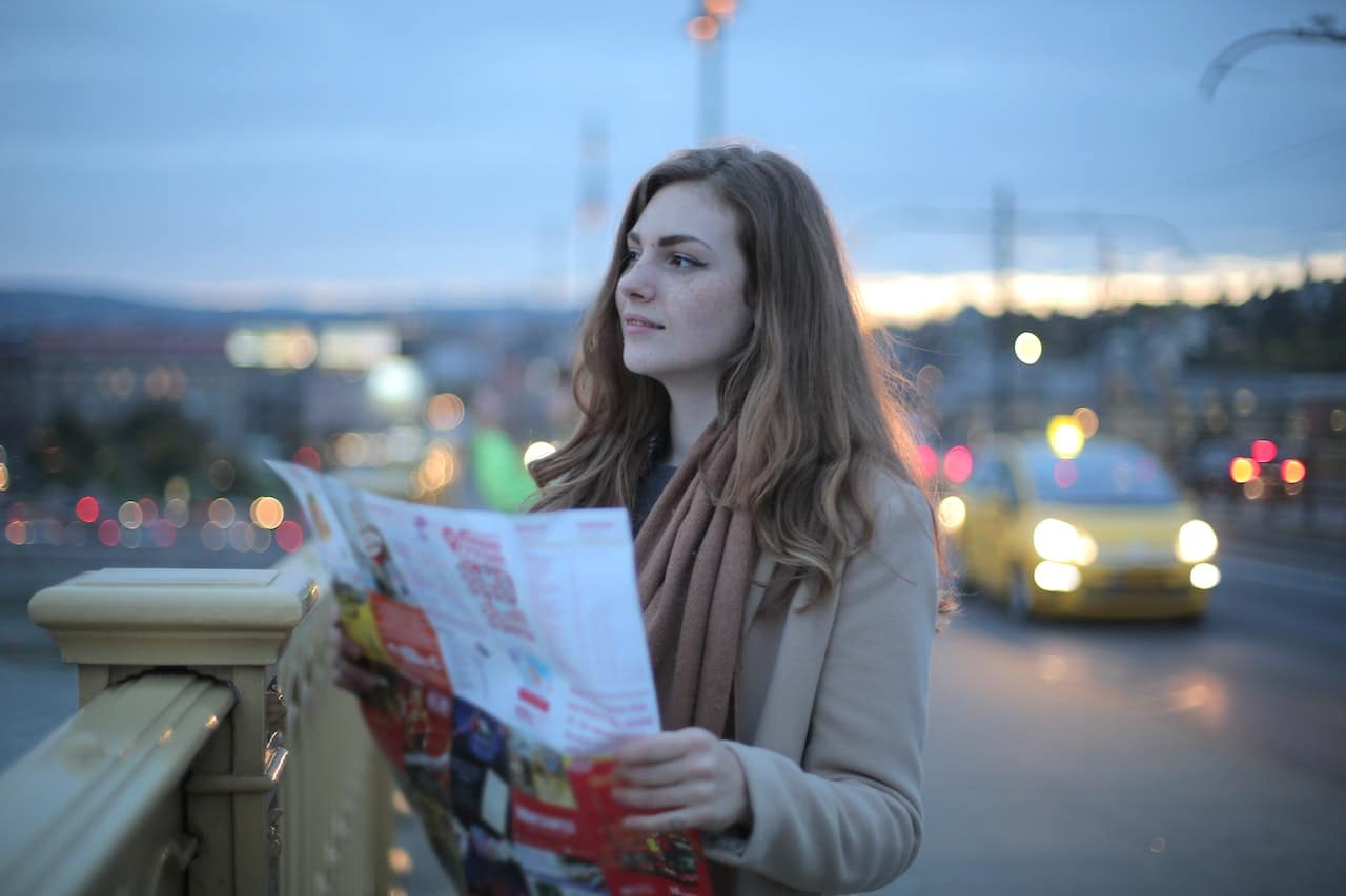 A woman reading a map that tells her what the best things to do in San Francisco for newcomers are