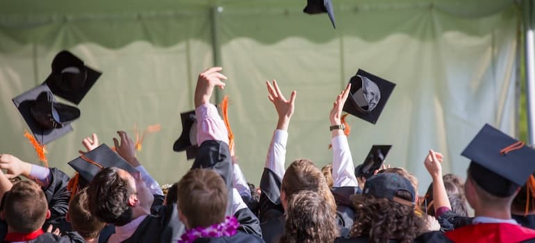 graduates throwing their graduation caps