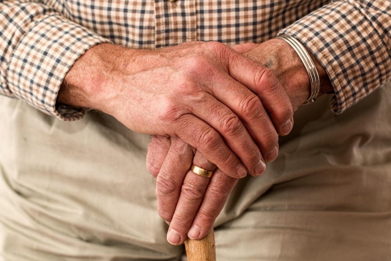 An older man crossing hands