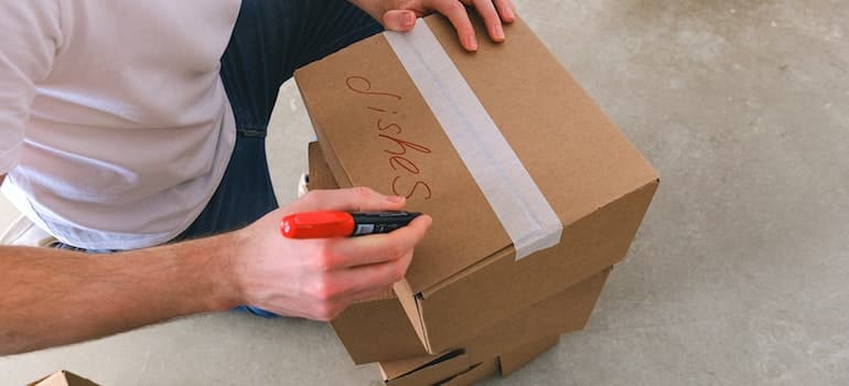 a man labeling a box, which is also one of the packing tips for seniors while packing